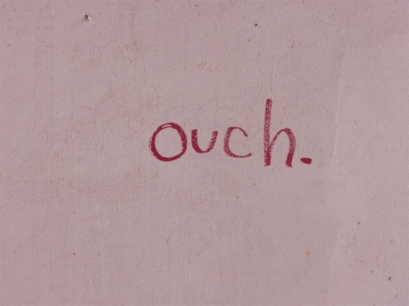 The word ouch written on a pink background